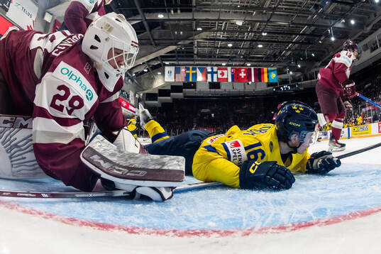 Goaltender Linards Feldbergs of Latvia and Felix Unger