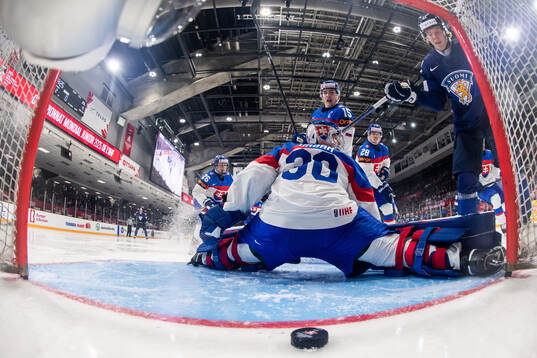 Topias Hynninen of Finland scores a goal behind goaltender