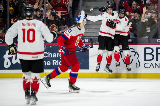 Porter Martone and Gavin McKenna of Canada celebrate