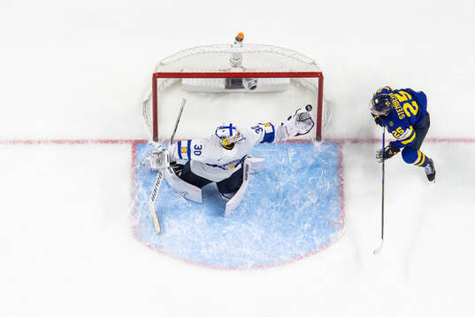 Goaltender Petteri Rimpinen of Finland with a save next to