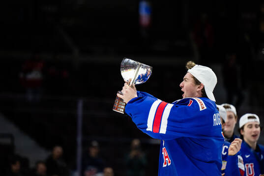 Goaltender Trey Augustine of USA celebrates with the trophy