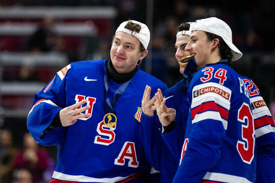 Goaltender Trey Augustine, Zeev Buuim and Gabe Perreault of