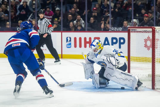 Teddy Stiga of USA scores 4-3 behind goaltender Petteri