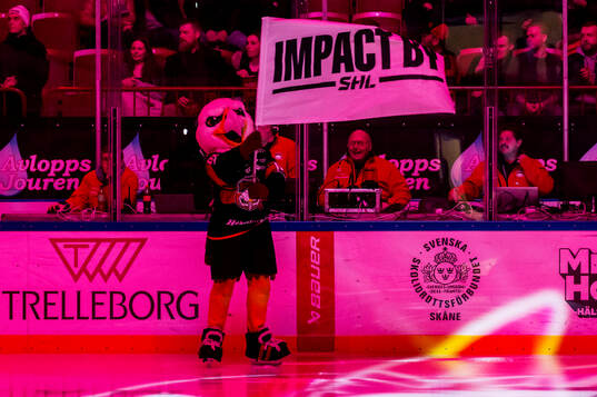 Malmö Redhawks maskot Hawkan med en Impact by SHL-flagga