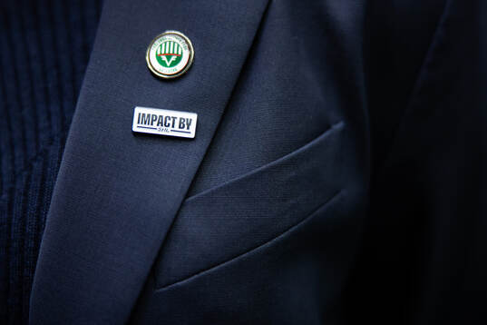 En Frölunda pin och en pin med Impact by SHL på ett