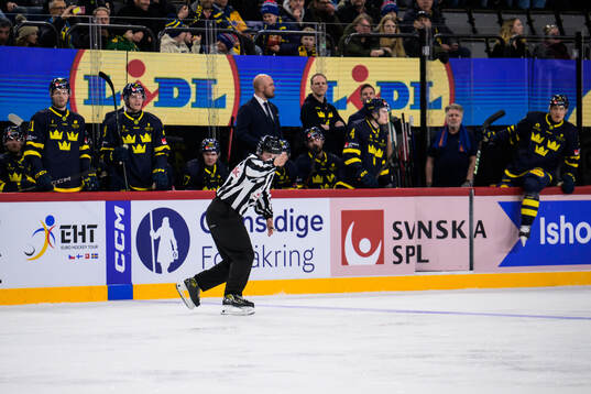 A linesman in front of the Swedish bench