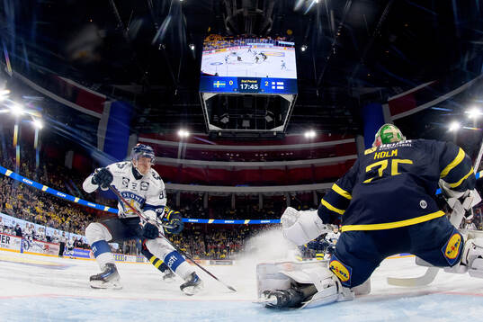 Saku Maenalanen of Finland and goalkeeper Arvid Holm of