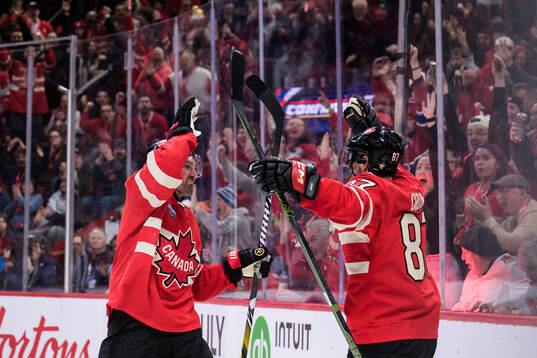 Mark Stone and Sidney Crosby of Canada celebrate the 3-1