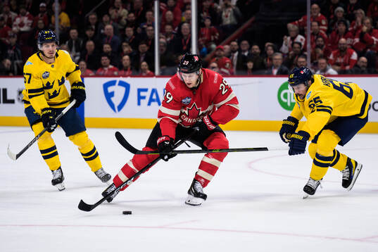 Rickard Rakell and Erik Karlsson of Sweden are being