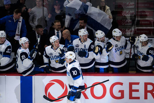 Henri Jokiharju of Finland celebrates with teammates