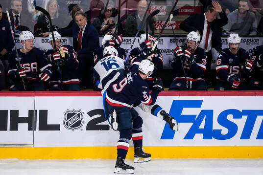 Jack Eichel of USA tackles Aleksander Barkov of Finland