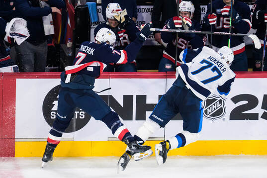 Brady Tkachuk of USA tackles Niko Mikkola of Finland