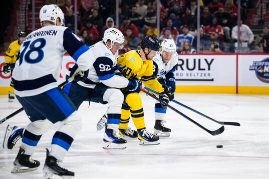Patrik Laine and Nikolas Matinpalo of Finland are being