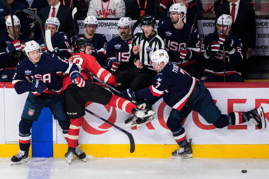 Zach Werenski and Brady Tkachuk of USA are being challenged