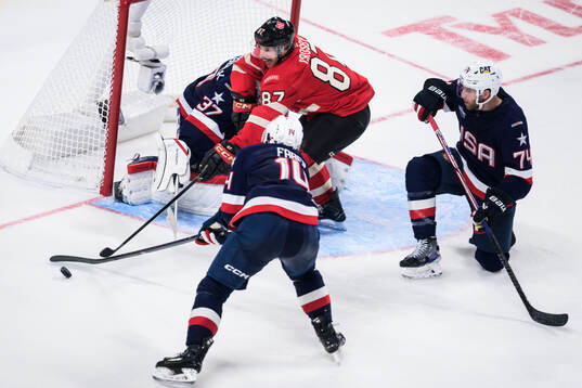 Sidney Crosby of Canada challenges Brock Faber, goaltender