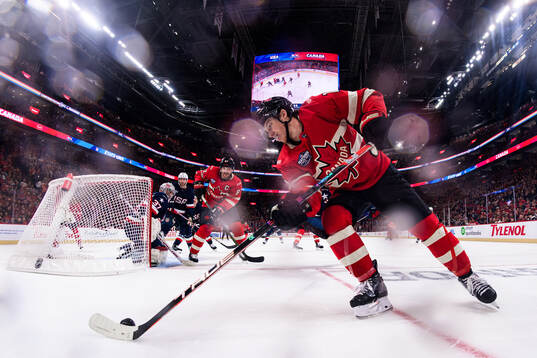 Goaltender Connor Hellebuyck of USA is being challenged by