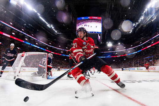 Goaltender Connor Hellebuyck of USA is being challenged by