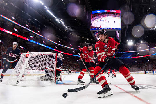 Goaltender Connor Hellebuyck of USA is being challenged by