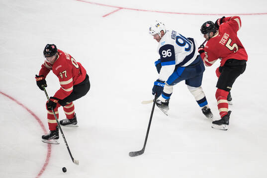 Connor McDavid and Devon Toews of Canada in action against