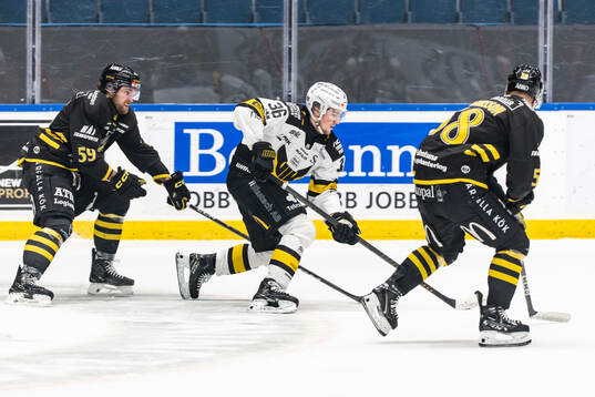 AIKs Macoy Erkamps och Oskar Magnusson i kamp om pucken med