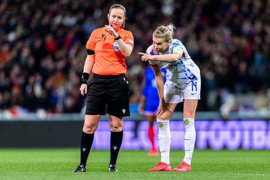 Referee Cheryl Foster and Ada Hegerberg of Norway