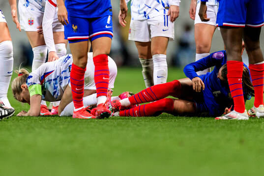 Ada Hegerberg of Norway and Sandie Toletti of France in pain