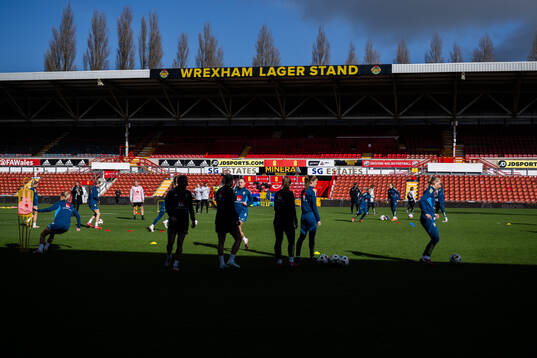 A stand at Racecourse Ground with players of the Swedish