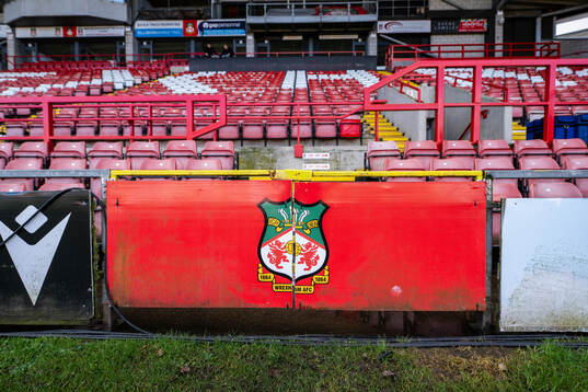 The club Crest of Wrexham is seen below stands at