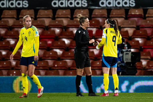 Referee Désirée Grundbacher and Kosovare Asllani of Sweden