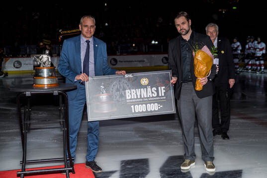 Brynäs sportchef Johan Alcén tar emot en pokal och check