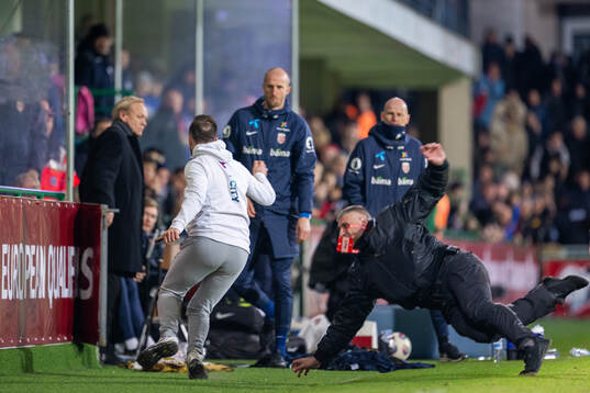 A pitch invader runs towards the bench of Norway