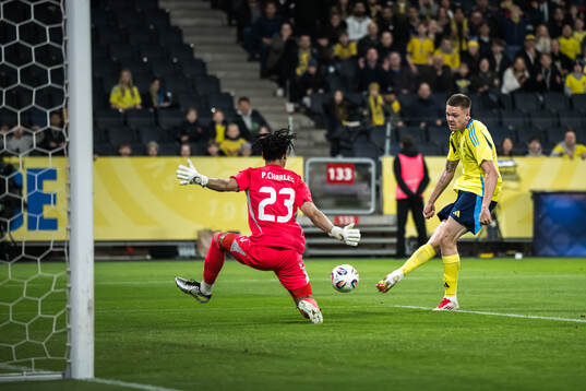 Emil Holm of Sweden scores the 1-0 goal against goalkeeper