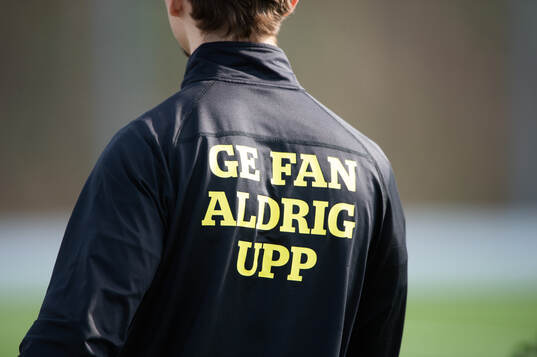 Budskapet ”Ge fan aldrig upp” på ryggen i matchen