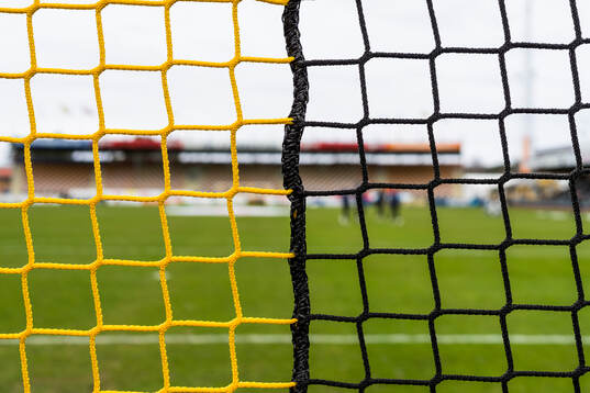 Gul-svart nätmaskor i ett fotbollsmål