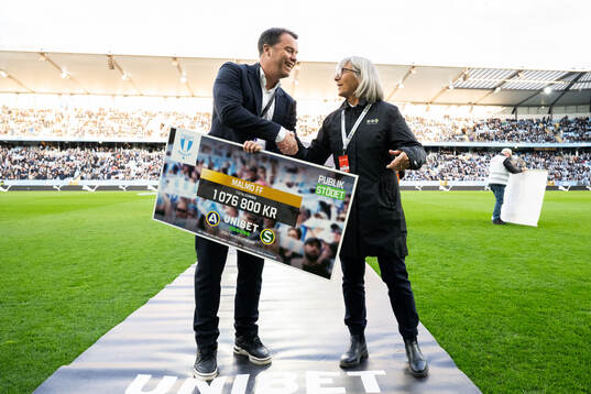 Malmö FFs sportchef Daniel Andersson tar emot en check