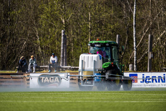 A tractor waters the pitch at half-time break