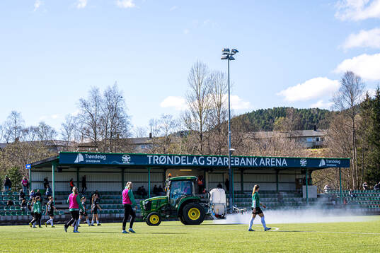 A tractor waters the pitch at half-time break