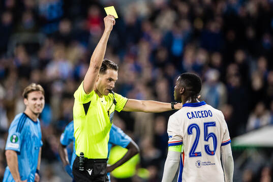 Referee Sandro Schärer shows a yellow card to  Moises