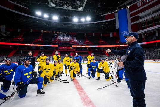Players of Sweden gather around assistant coach Anders