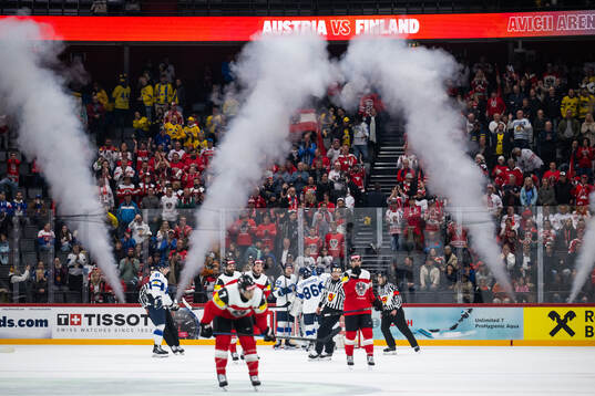 Players of Finland celebrate while players of Austria look
