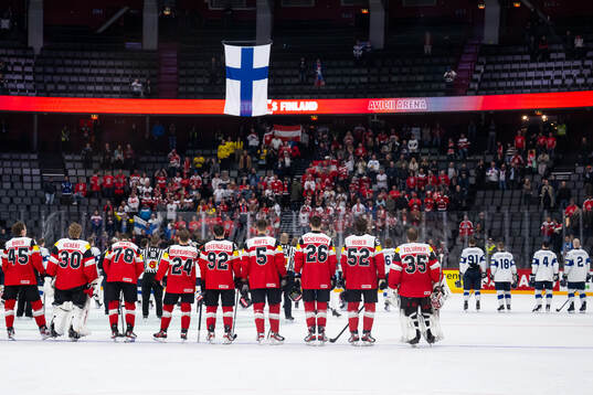 Players of Austria and of Finland listen to the national