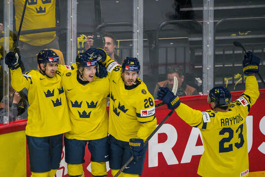 Mikael Backlund and Elias Lindholm celebrate with Leo