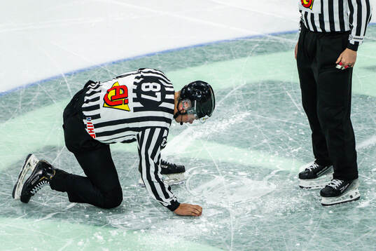 Linesman Shane Gustafson repairs the ice