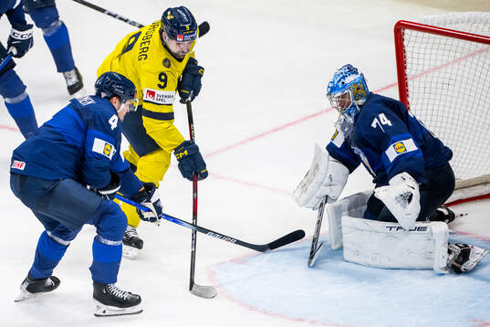 Mikko Lehtonen and goaltender Juuse Saros of Finland defend