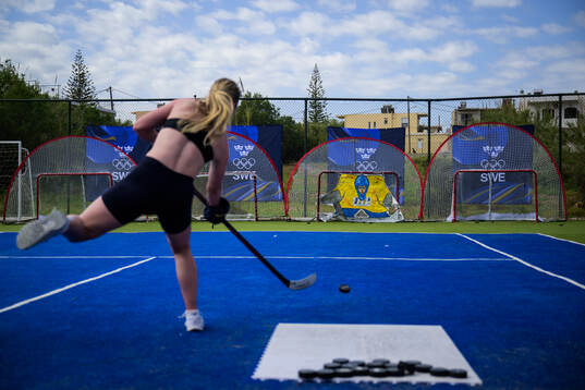 An ice hockey athlete of Sweden shoots a puck at a training