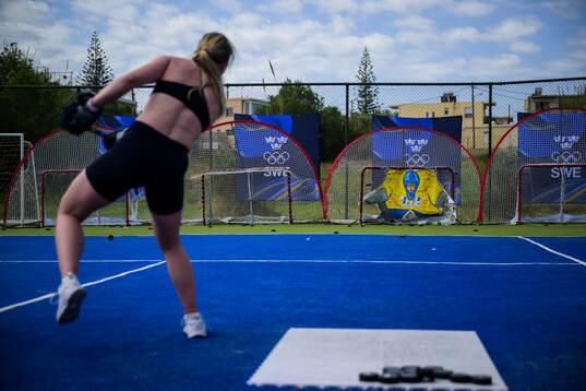 An ice hockey athlete of Sweden shoots a puck at a training