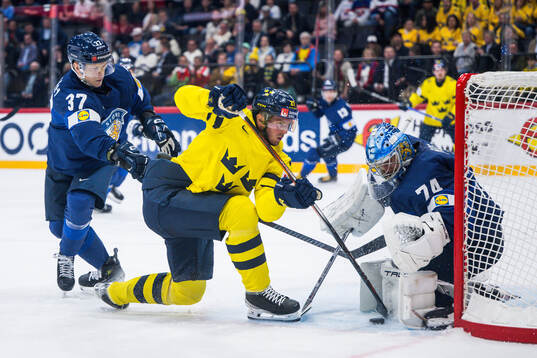 Atro Leppänen and goaltender Juuse Saros of Finland defend