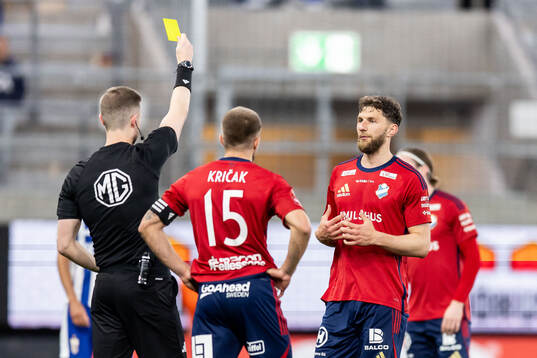 Domare Erik Mattsson ger gult kort till Östers Alibek Aliev