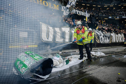 Brandman släcker en Hammarbys trumma framför AIKs