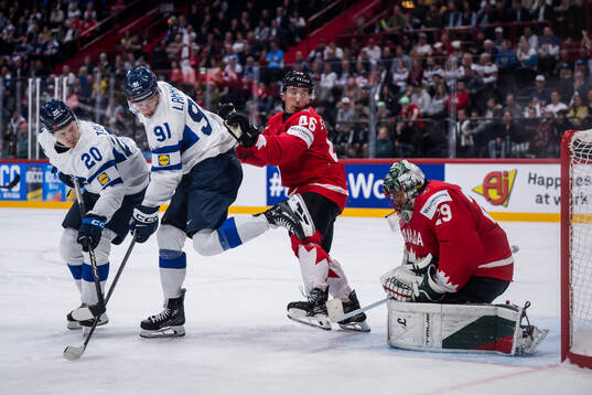 Eeli Tolvanen and Juho Lammikko of Finland with goaltender